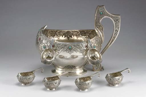 Большой (40x26 см) серебряный ковш и шесть маленьких (13x7 см) с чеканным лиственным узором.